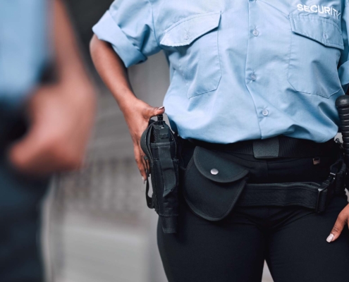 Security guard walking with firearm in holster