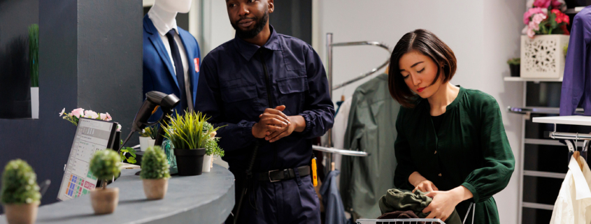 retail security officer wearing uniform standing at clothes shop